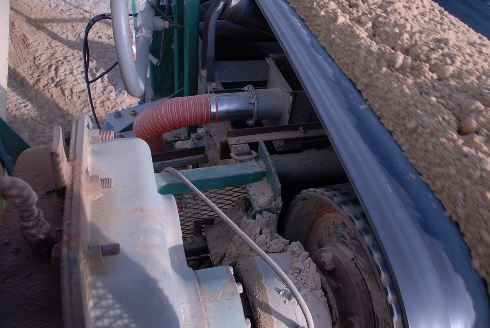 Belt Drive Roll Heater in action on a conveyor belt moving sand.